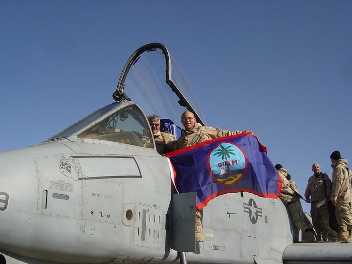 Peter J. Santos holding the flag of Guam at a forward airfield in Afghanistan